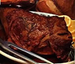 Image showing baked joint of meat with sliced lemon garnish