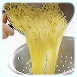 An image of spaghetti being drained in colander